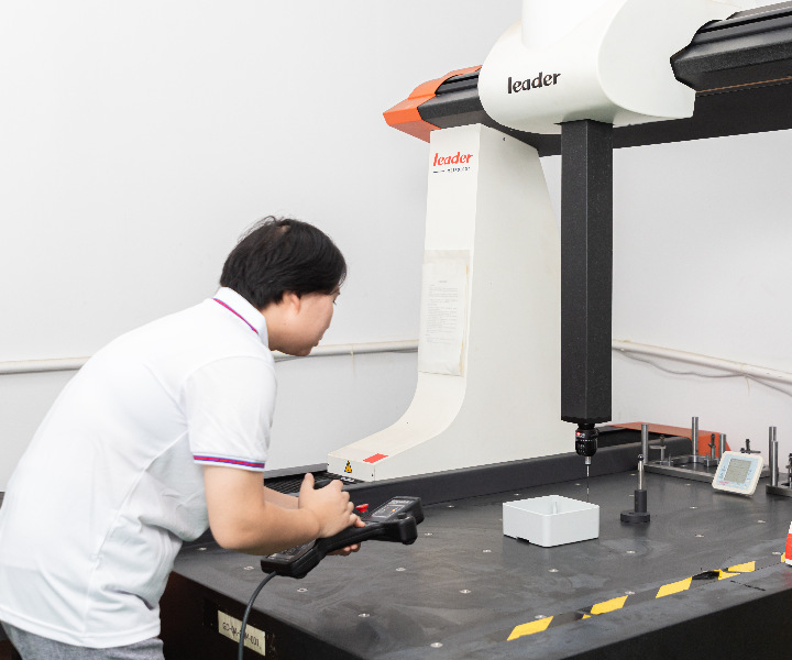 A quality inspector uses a Coordinate Measuring Machine to inspect injection molds.