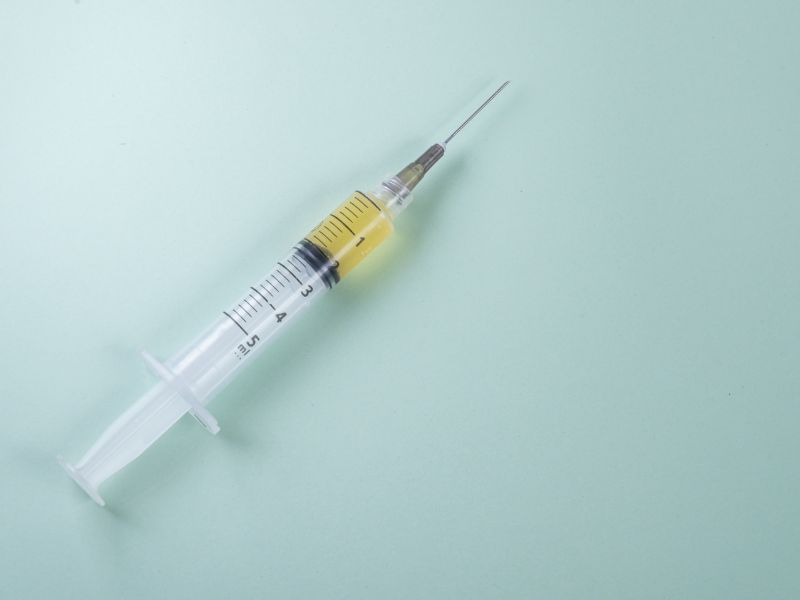 plastic syringe green background 1